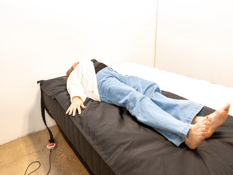 A woman lies on a pressure map mat on the Titan Plus Core hybrid mattress to measure pressure relief.