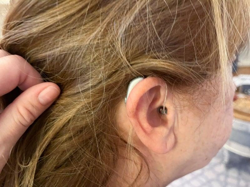 A woman wearing the Jabra Enhance Select 700 hearing aids