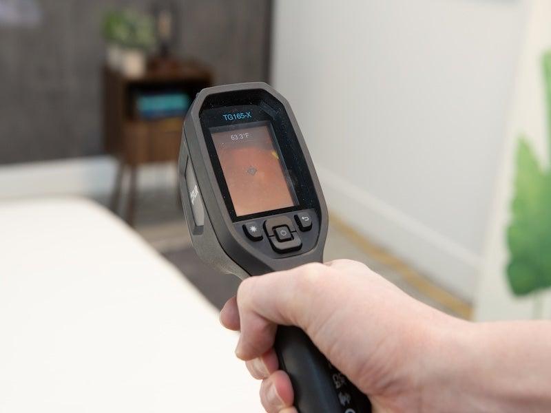 A heat gun aimed at the mattress reads 63.3 degrees.