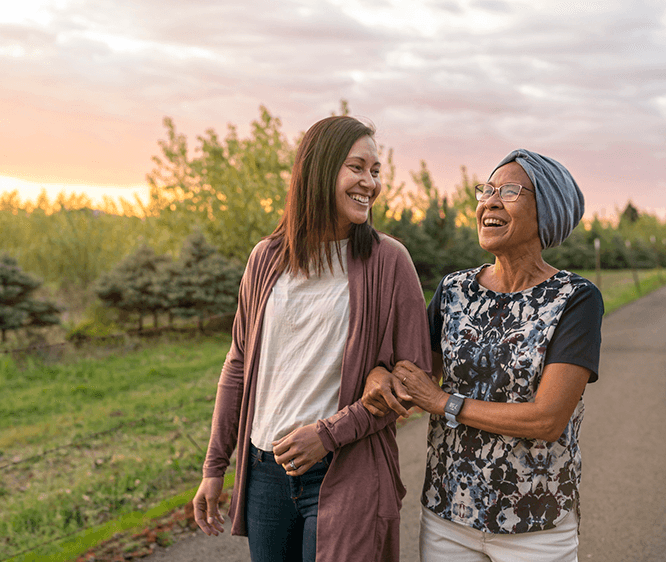 smiling older woman and adult daughter walking outside
