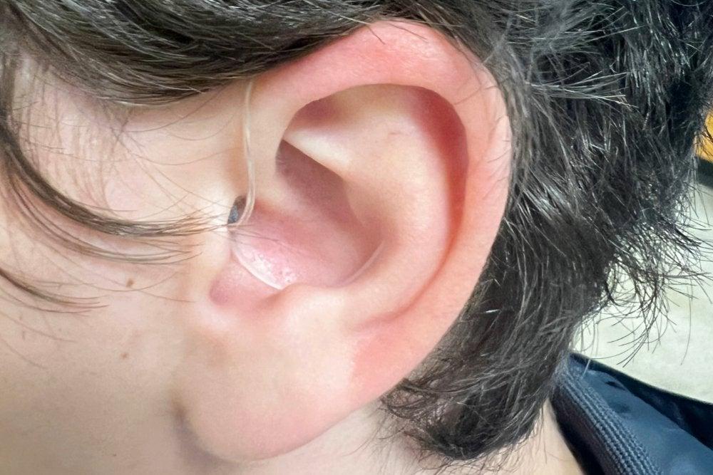 Jabra hearing aid with sports lock in man's left ear