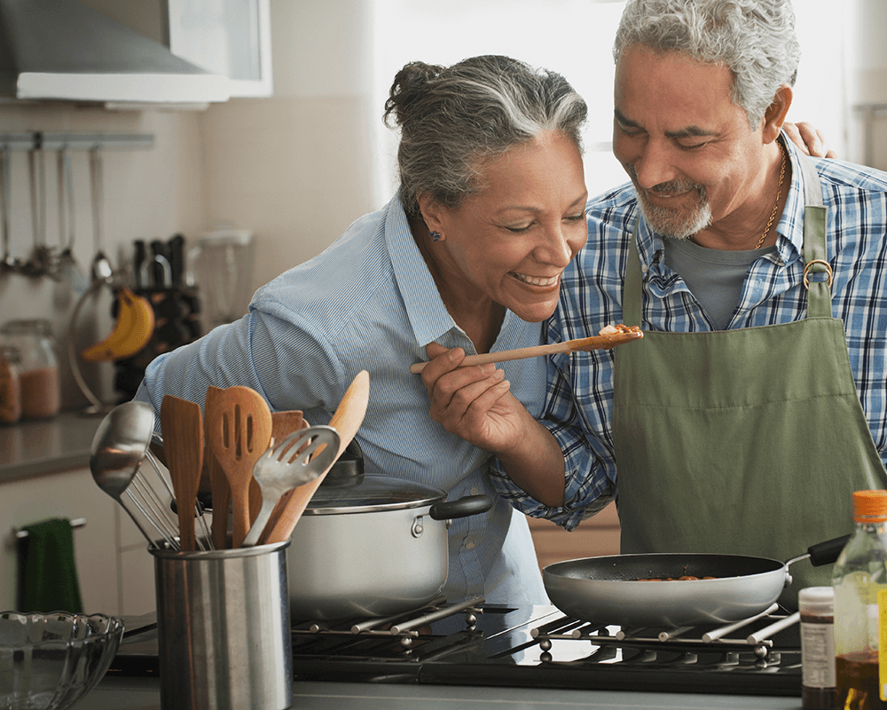 older man and women cooking together