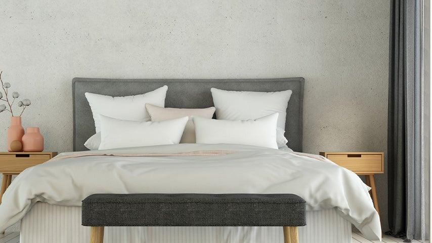 bed with comforter, five pillows, two nightstands
