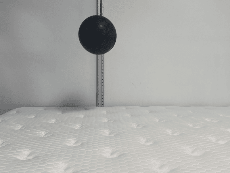 A medicine ball bouncing on the Plank Firm Luxe mattress