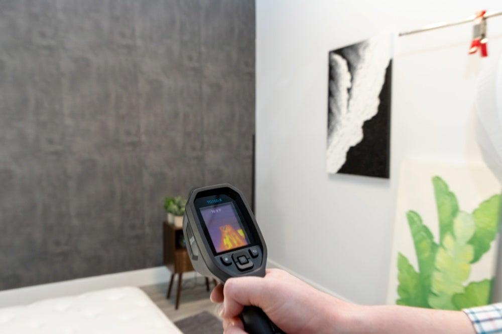 A person points a temperature detector at the Winkbed Luxury Firm mattress