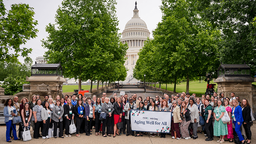 Ramsey Alwin and NCOA advocates holding Aging Well for All sign in front of U.S. Capitol