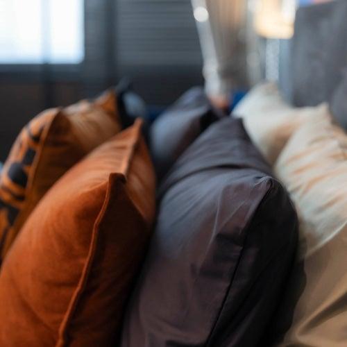 A stack of silk pillowcases on a bed