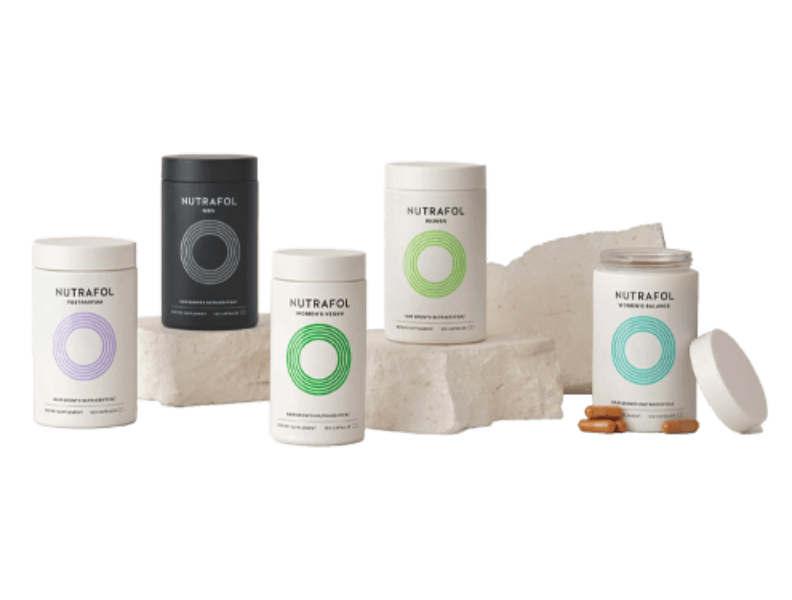 Four different Nutrafol supplement bottles in front of a white background