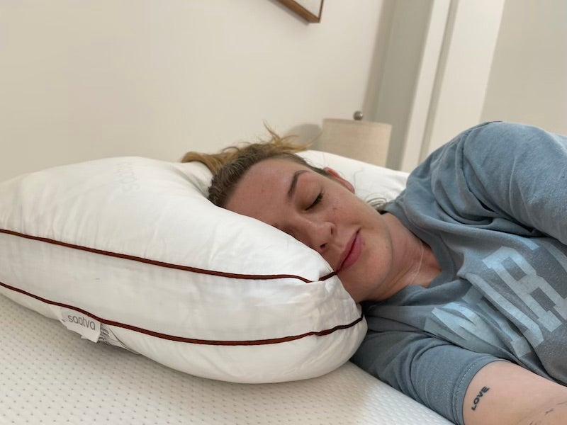 A woman sleeps on her side on a Saatva latex pillow.