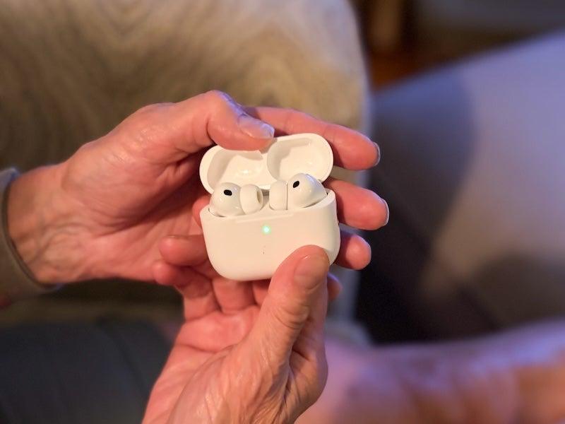 A woman holds the Apple AirPods Pro 3 in their charging case