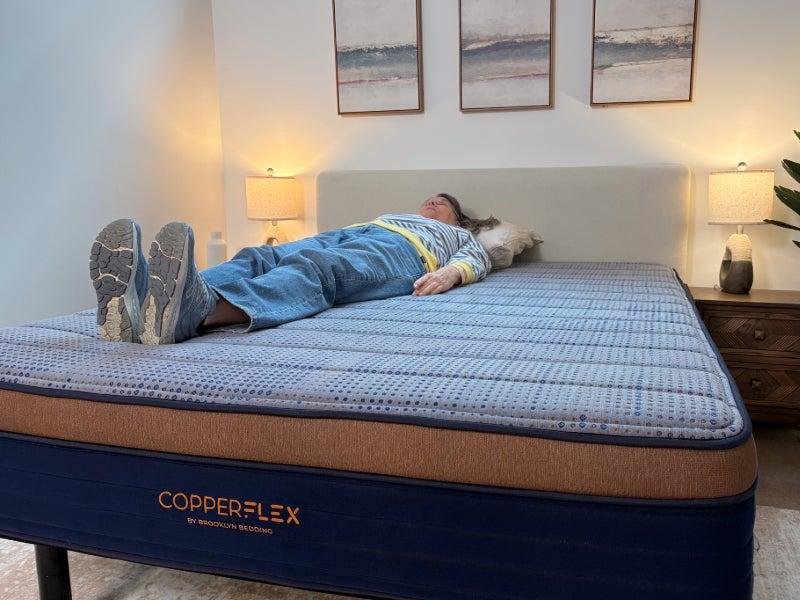 A person lying on their back on the Brooklyn Bedding CopperFlex Memory Foam mattress