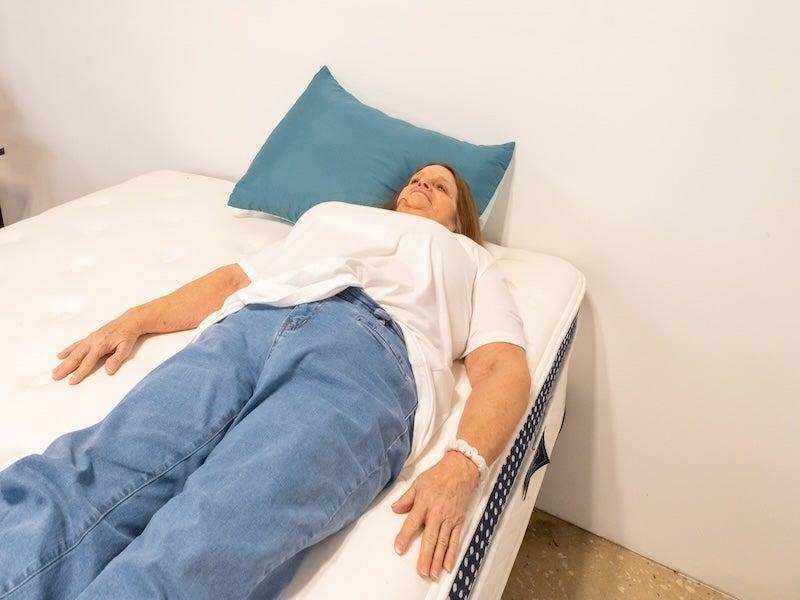 A woman lying on her back on the WinkBed Plus mattress