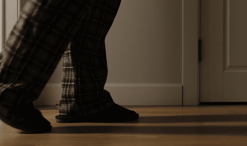 A person walks down a hallway at night