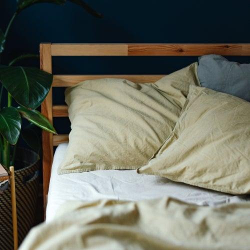 A bed with comfortable-looking pillows and rumpled sheets