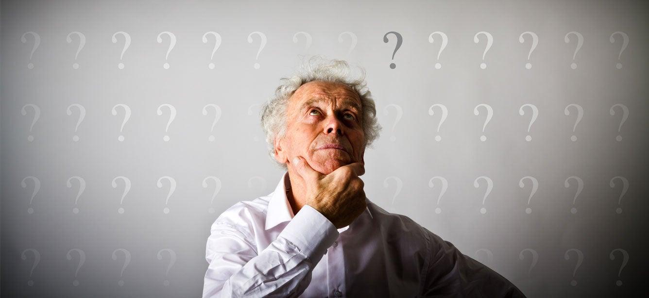 A senior man is looking up, where many question marks surround him - indicating that he's trying to make a decision.