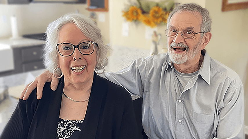smiling older couple in their kitchen