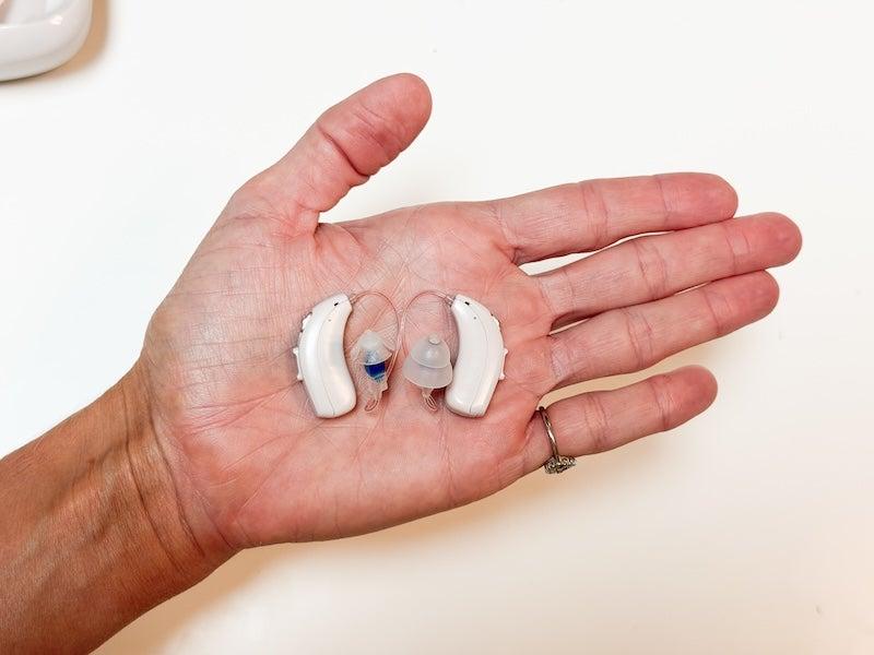 Two Linner Mercury RIC hearing aids in the palm of a hand