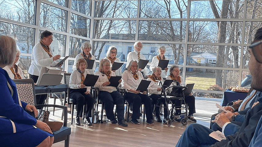 senior center chorus performing in sun-filled multipurpose room