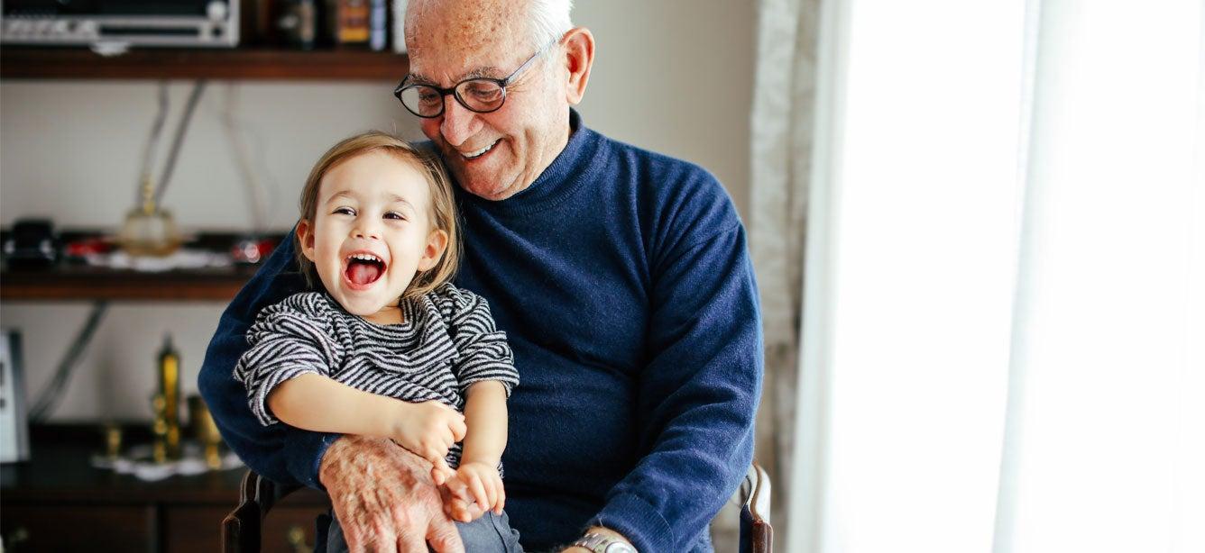 Senior man hugging a grandchild.