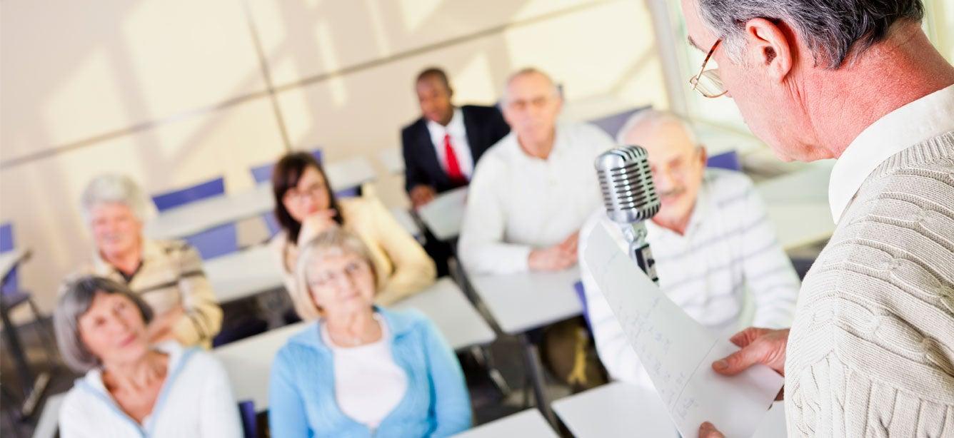 A senior man is talking in front of an audience about issues that matter to him.