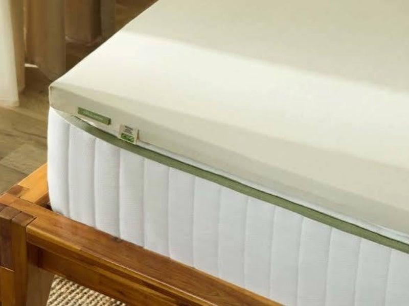 The corner of the Silk & Snow Mattress Topper on a mattress