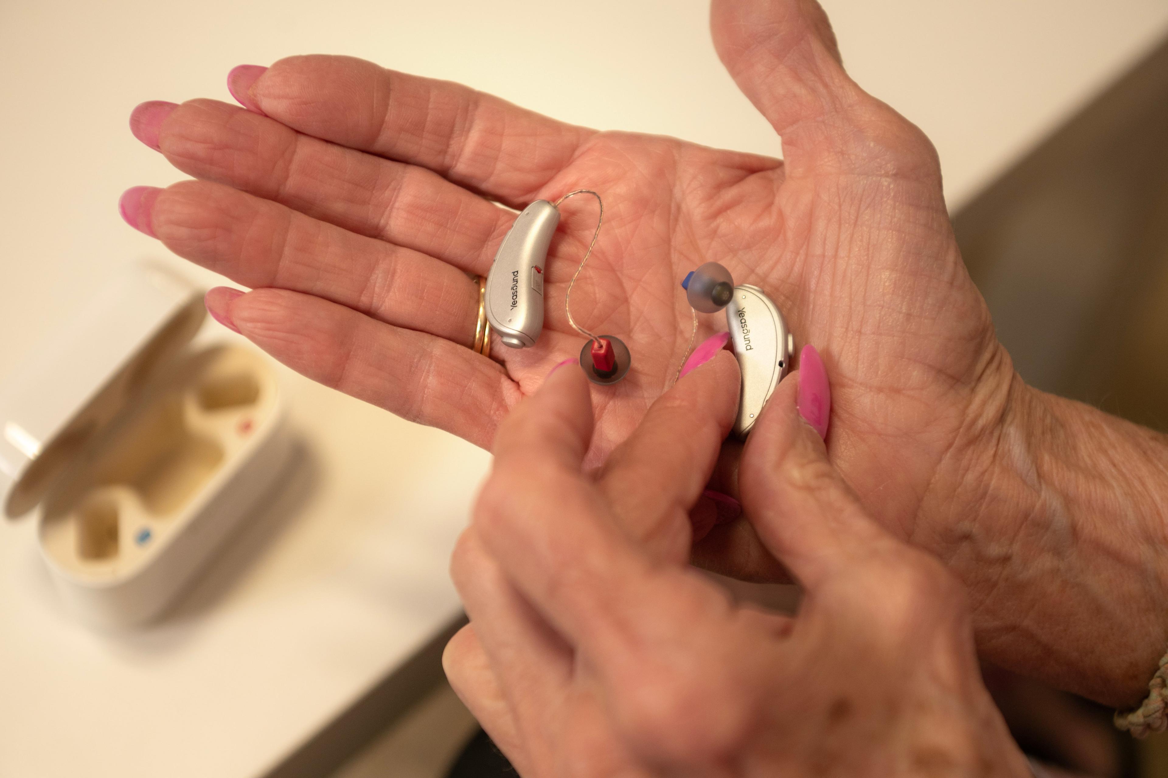 A woman holds the Yeasound RIC800 hearing aids in her palm