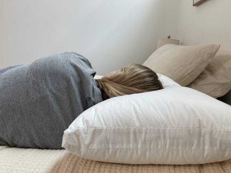A woman sleeps on her side on the Silk & Snow pillow.
