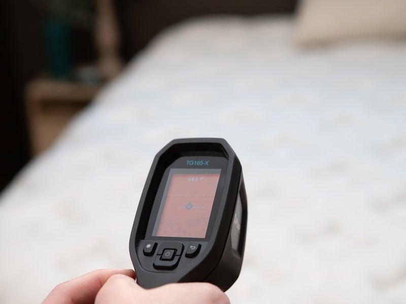 A heat-detecting gun pointed at a Helix Midnight Luxe mattress