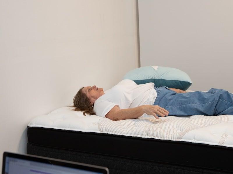 A woman lying on her back on the Nolah Evolution Luxury Firm mattress.