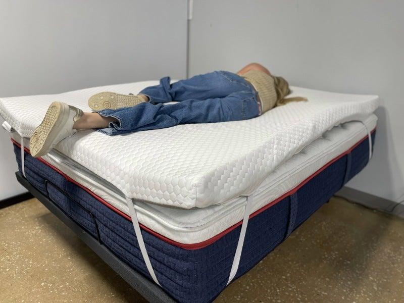 A woman lying on her side on the Helix mattress topper
