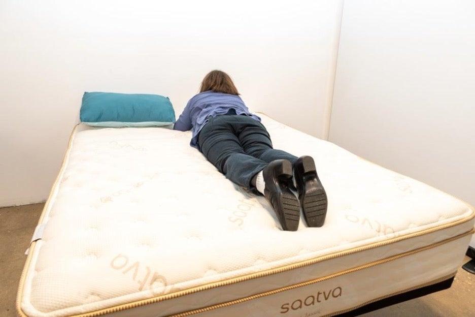 A woman lying on the Saatva Classic mattress on her stomach