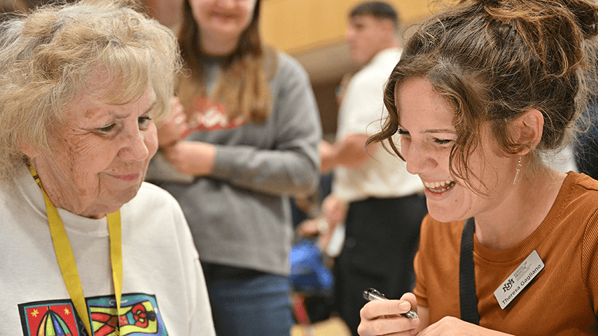 smiling young woman talking to older woman