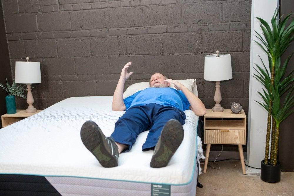 Man lies on his back on the Nectar Premier Hybrid mattress