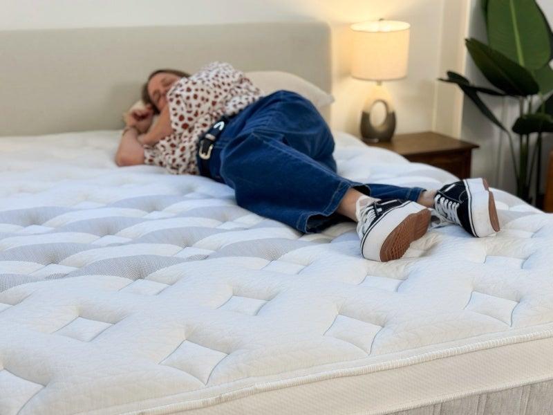 A woman lying on her side on the Leesa Sapira Chill hybrid mattress