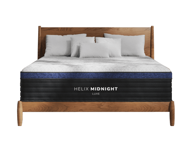 The Helix Midnight Luxe Mattress with pillows and a wooden headboard