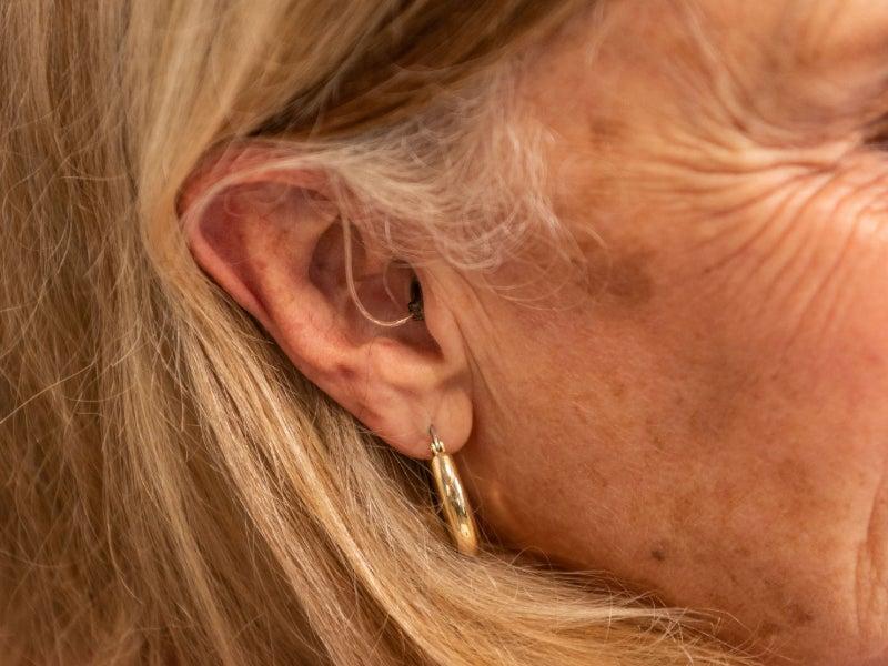 A woman wearing the Sennheiser All-Day Clear RIC hearing aids