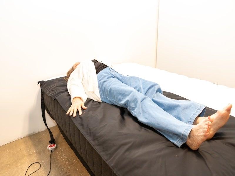 A woman lying on her back on a pressure map on top of the Titan Plus mattress.