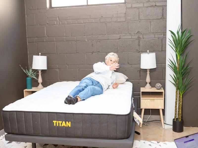 A woman rolls from one side to another on the Titan Plus mattress