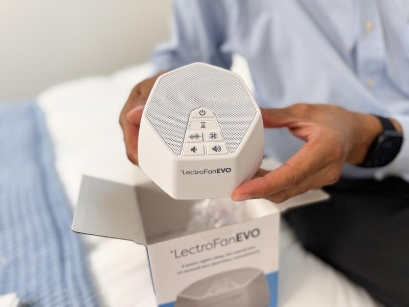 A man’s hands hold up a LectroFan Evo sound machine console