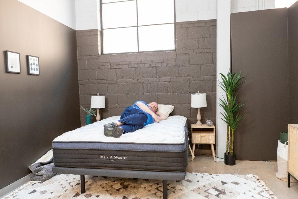 Older man lies on his side on a bed
