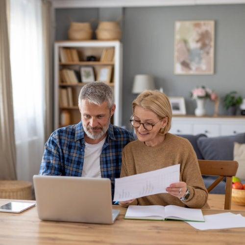 A man and a woman review their estate plans in front of a computer