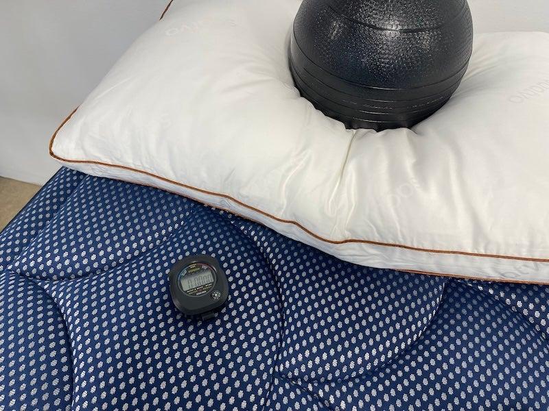 The Saatva Latex pillow under a medicine ball