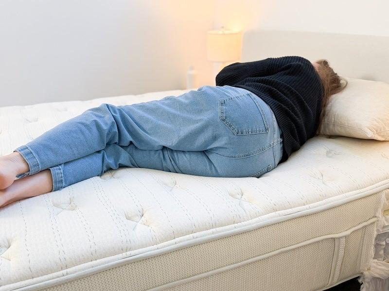A woman lies on her side on the Leesa Natural Hybrid latex mattress