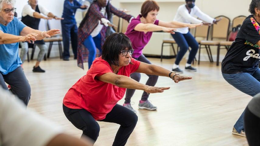 People squatting in a group fitness class.