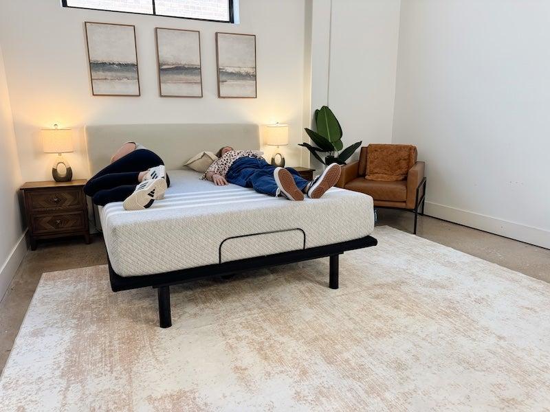 A woman lies on her back on the Leesa Natural Hybrid latex mattress next to another person