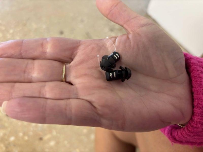 Eargo 8 hearing aids sitting in the palm of a person's hand