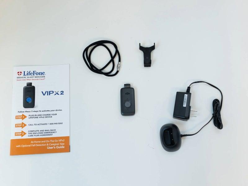 The LifeFone VIPx2 and its included lanyard, belt clip, user guide and charger