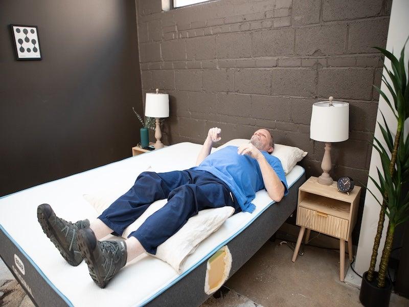 A man lies on his back near the edge of the Bear Original memory foam mattress
