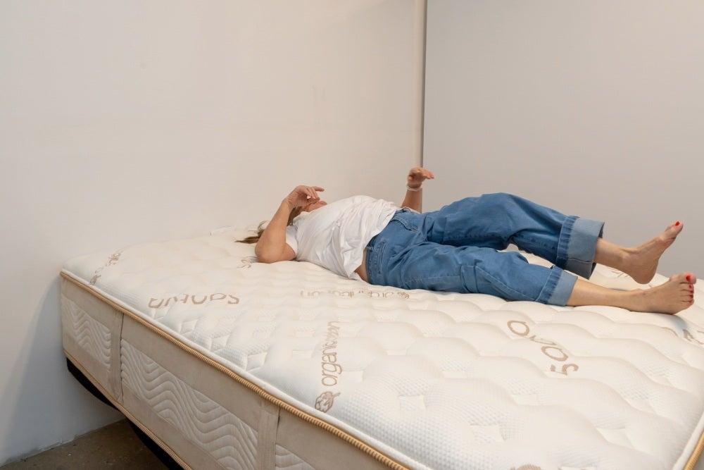 A woman rolling over on a Saatva Rx mattress