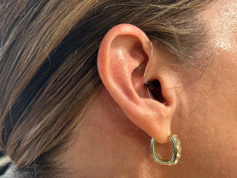 A close-up picture of a person's ear wearing Starkey hearing aids
